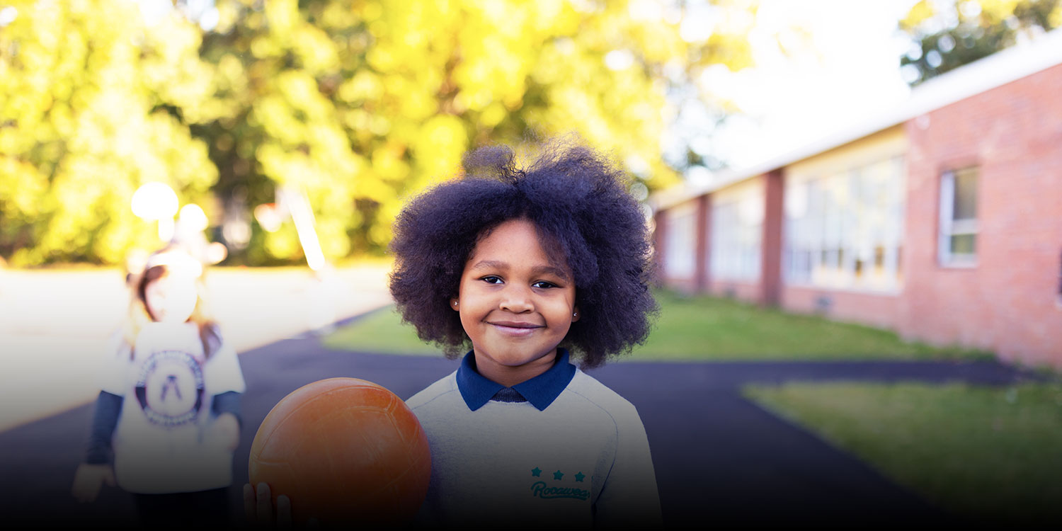 Smiling student holding a basketball